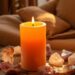 Lit orange candle surrounded by crystals