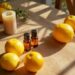 Lemons, essential oil bottles, and a candle on a sun-dappled wooden table